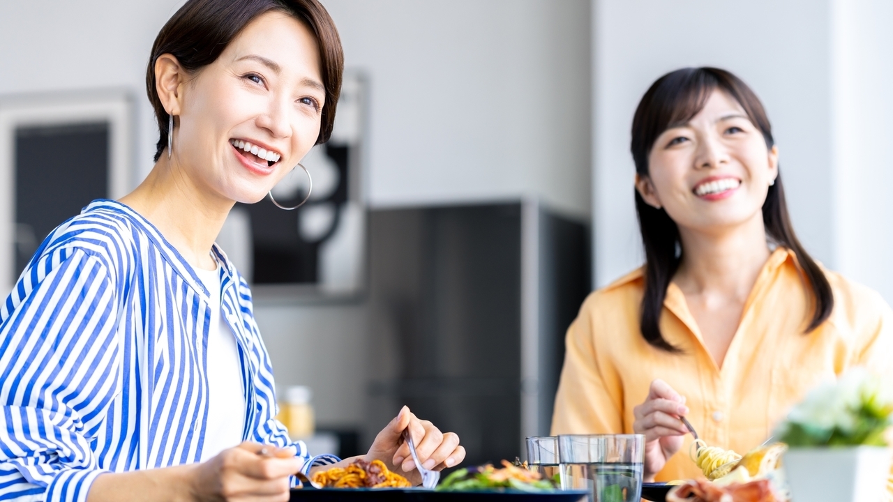 家族と食卓を囲み食事を楽しむ女性